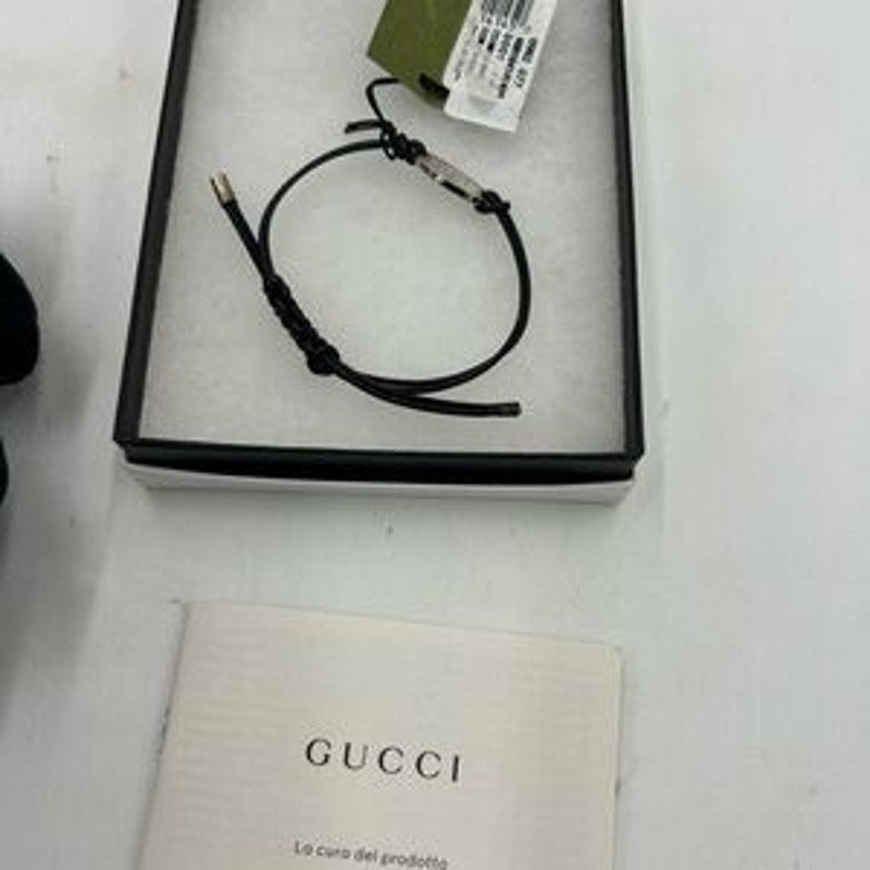 Gucci, black leather cord bracelet with sterling silver logo engraved plaque