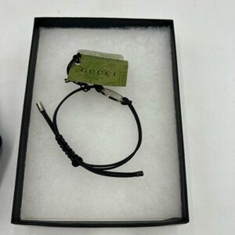 Gucci, black leather cord bracelet with sterling silver logo engraved plaque