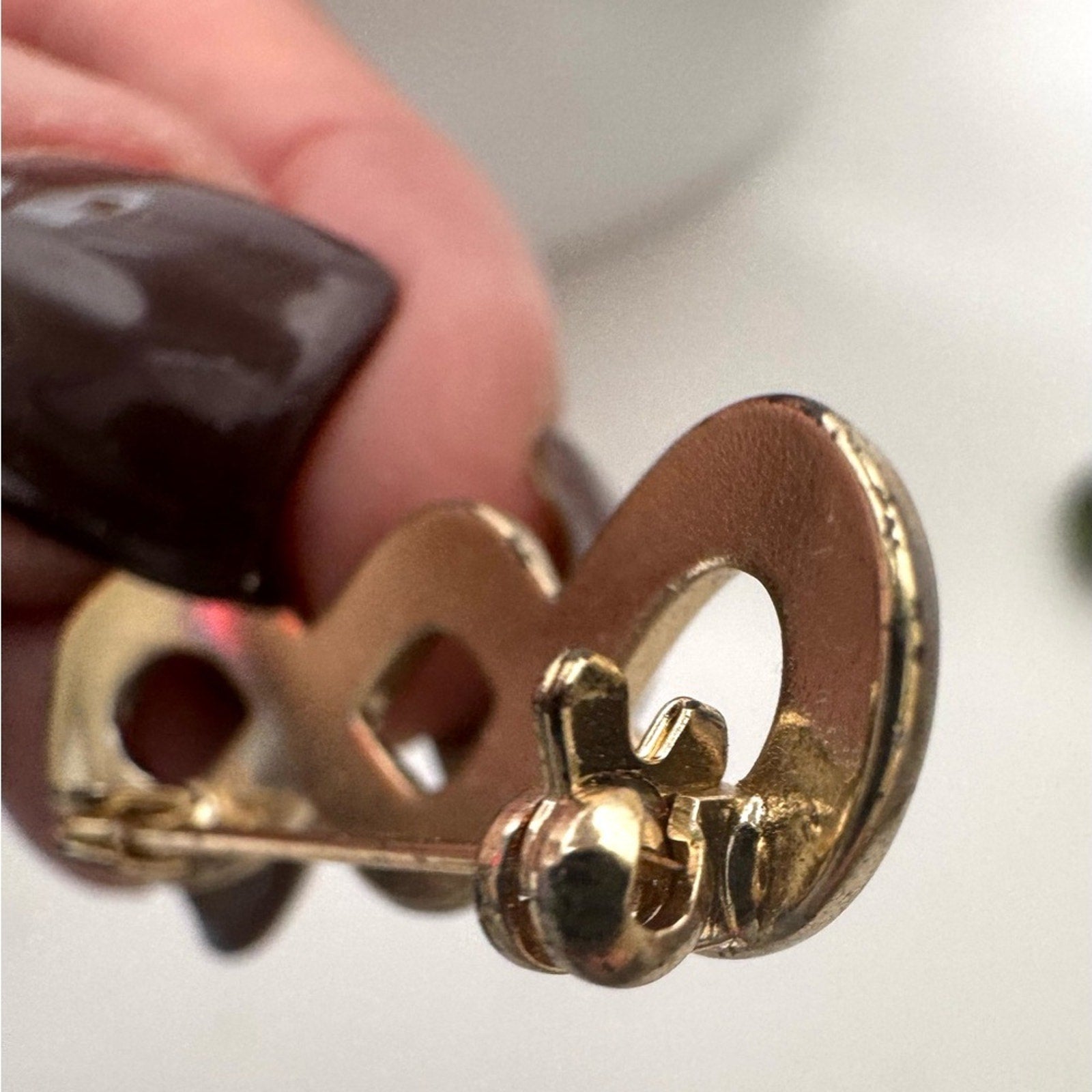 Gold Infinity pin with a closure that rotates around to keep it secure