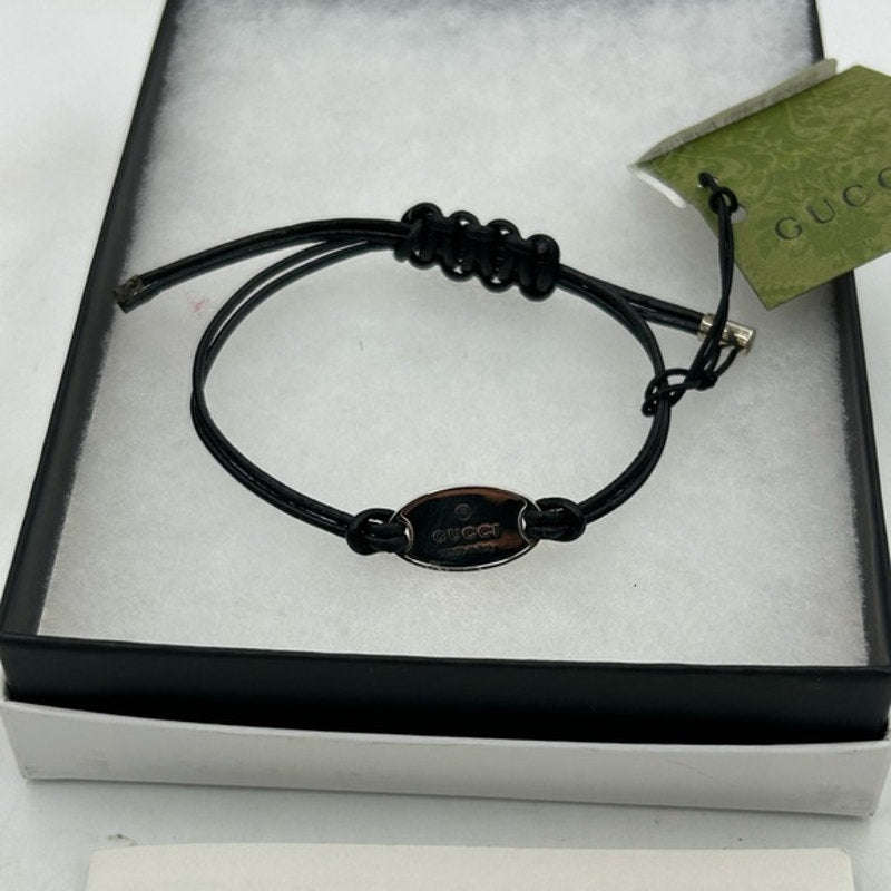 Gucci, black leather cord bracelet with sterling silver logo engraved plaque