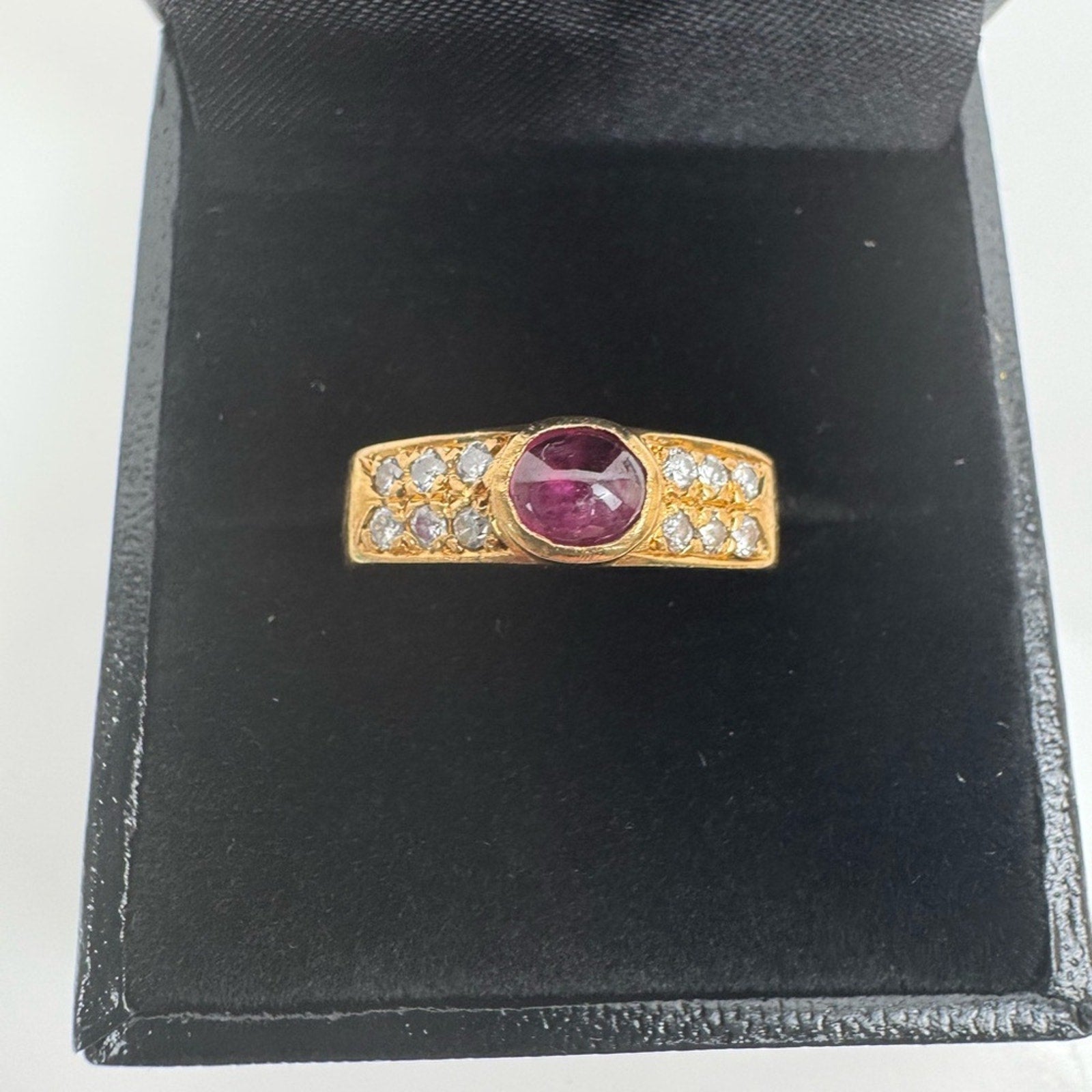 Cabochon Ruby ring set with diamond stones set in an 18 karat gold band