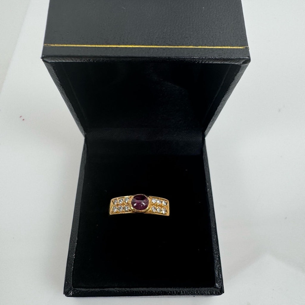 Cabochon Ruby ring set with diamond stones set in an 18 karat gold band